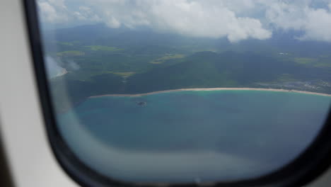 Female-opening-sunshade-on-airplane-while-flying-revealing-Philippines-coastline