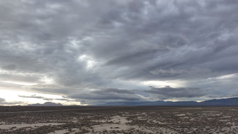 Dark,-ominous-clouds-gather-above-the-flat-landscape-of-the-Mojave-Desert---aerial-hyper-lapse