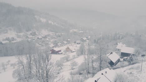 Aerial-landscape-of-countryside-covered-by-fog-and-snow-in-winter-morning
