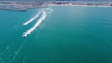 Aerial-view-of-the-mediterranean-sea-with-jetski's-passing-by-in-Carnon,-Montpellier,-France