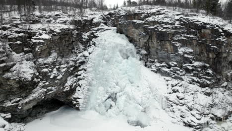 Gefrorener-Wasserfall-Auf-Klippen-In-Verschneiter-Winterlandschaft