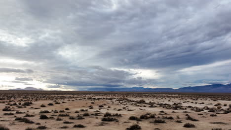 Das-Mojave-Wüstenbecken-Unterhalb-Der-Fernen-Bergkette-An-Einem-Bewölkten-Tag---Gleitende-Luftüberführung