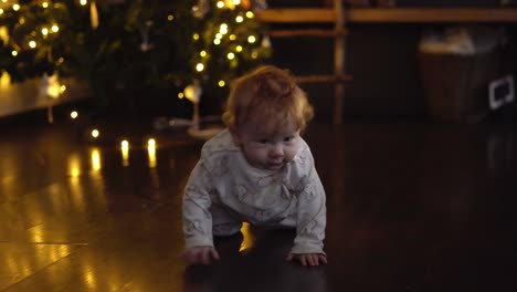 Crawling-baby-girl-in-front-of-the-christmas-tree-in-the-living-room