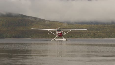 Floatplane-moving-towards-camera-with-spinning-propeller-on-calm-lake