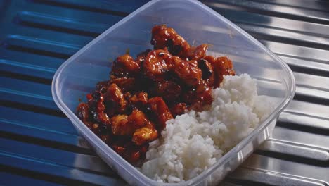 Sweet-and-sour-chicken-with-rice-getting-into-focus,-healthy-homemade-food-in-a-tupper