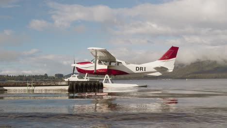 Pilot-jumping-onto-floating-jetty-to-secure-floatplane,-docking-seaplane