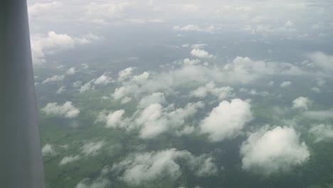 Above-clouds-view-of-rural-Costa-Rica-with-open-fields-and-jungle,-Aerial-airplane-view-shot