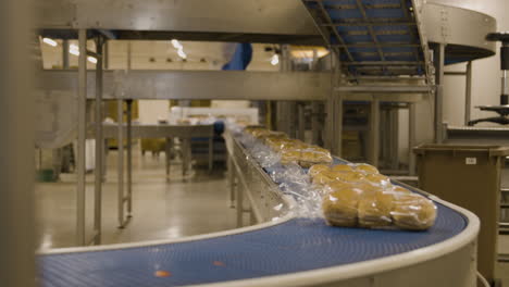 Packets-of-bread-buns-rolling-down-a-conveyor-belt