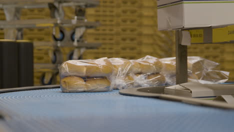 Brotbrötchen-In-Kunststoffverpackungen,-Die-Ein-Förderband-Hinunterrollen