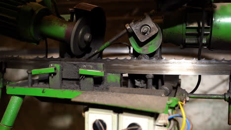Bandsaw-sharpening-machine-operator-adjusting-grinding-settings-for-maintenance