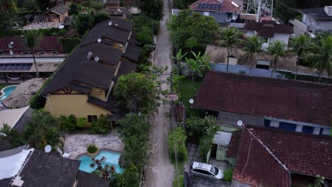 Vista-Aérea-Sobre-Calles-Y-Casas-En-Barra-Do-Sahy,-Anochecer-En-Brasil---Inclinación,-Disparo-De-Drones