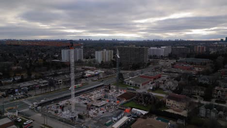 Wide-aerial-drone-shot-of-construction-site-with-a-crane-in-a-suburban-area