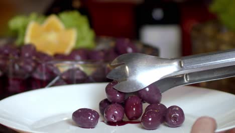 Close-up-of-a-person-serving-grapes-as-dessert-with-sweet-sauce-on-a-plate-in-slow-motion