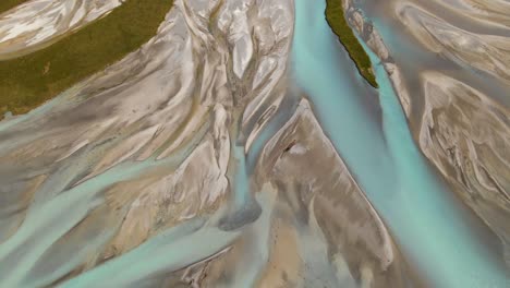 Aerial---river-delta-with-turquoise-glacier-water-flowing-into-Lake-Tekapo,-New-Zealand