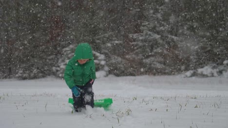 Niño-Tirando-De-Su-Trineo-A-Través-De-La-Nieve-Con-Nieve-Que-Cae-Suavemente-En-Cámara-Lenta