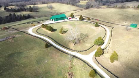Aerial-pullback-of-a-fence-pin-and-green-barn-in-Frankfort-Kentucky-on-a-beautiful-green-horse-farm
