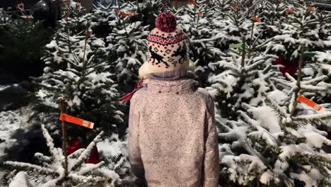 Junges-Mädchen-Geht-Durch-Geflogene-Kleine-Weihnachtsbäume,-Die-Mit-Schnee-Bedeckt-Sind