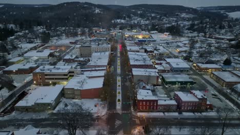 Aerial-orbiting-shot-of-snowflakes-falling-on-small-town-in-America