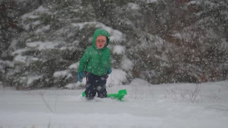 Young-Boy-Running-with-Sled-Through-the-Snow-While-Snow-Gently-Falls,-Slow-Motion