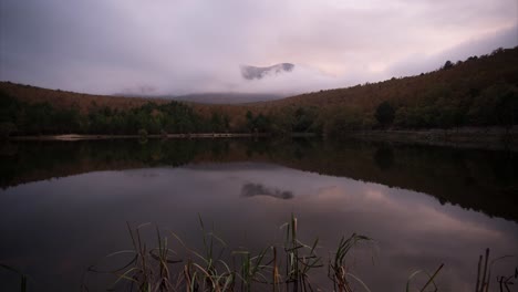 Timelapse-of-the-sunset-in-the-Moncayo-mountain,-with-reflection-in-the-lake,-rain-and-fog