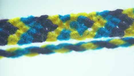 Macro-shot-of-a-blue-and-yellow-fabric-textile-bracelet,-4K