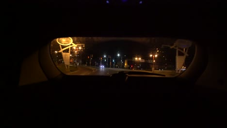 View-from-back-rear-window-of-SUV-from-interior-looking-out,-dark-night-drive