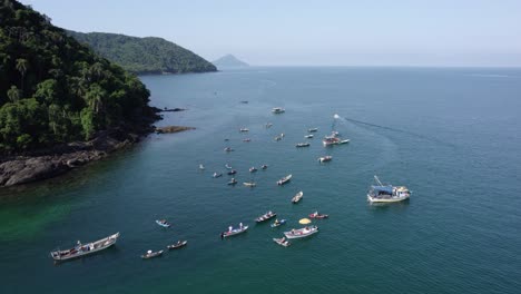 Aerial-view-around-fishing-boats-on-the-coast-of-Barra-Do-Sahy,-sunny-Brazil---orbit,-drone-shot