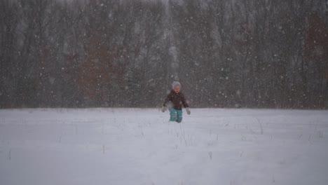 Toddler-Walking-Alone-Through-Deep-Snow,-Gently-Falling-Snow-in-Slow-Motion