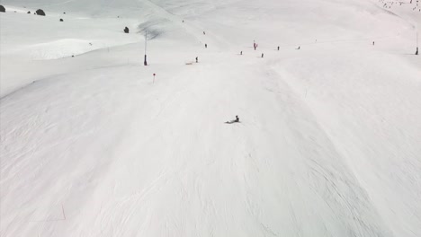 Vista-Aérea-De-Un-Esquiador-Descendiendo-Una-Pendiente