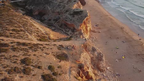 Luftaufnahme-Eines-Unsets-An-Einem-Strand-Voller-Surfer-In-Sagres-Portugal