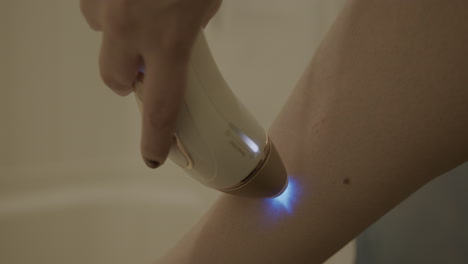 Close-Up-Slow-Motion-of-a-Woman-Using-an-Intense-Pulsed-Light-Hair-Removal-Device-on-Her-Leg