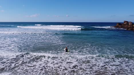 Una-Chica-Entrando-Al-Agua-Para-Empezar-A-Surfear-En-Una-Playa-En-El-Algarve,-Portugal