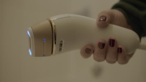 Close-Up-Slow-Motion-of-a-Woman-Holding-an-Intense-Pulsed-Light-Hair-Removal-Device