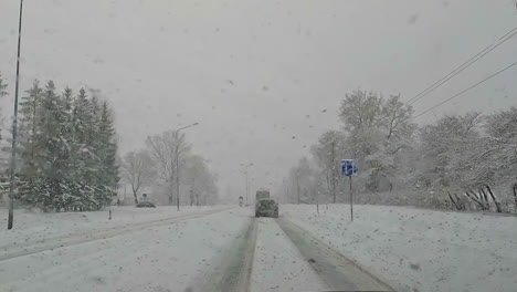 Shot-while-driving-car-on-a-heavy-snow-covered-road-with-heavy-white-snowfall-on-a-cloudy-day