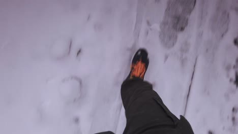 Walking-POV-looking-down-at-feet-following-snowy-footprints-on-peaceful-woodland-pathway