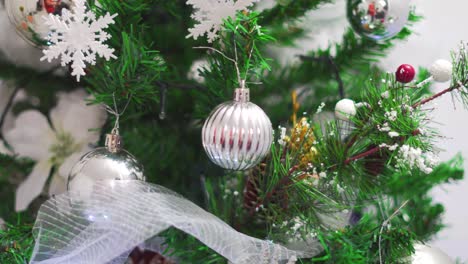 Detalle-Del-árbol-De-Navidad-Decorado-Con-Flores-Blancas-Y-Bolas-Plateadas