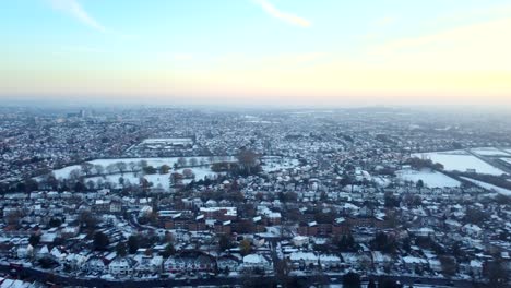 Wide-angle-establishing-aerial-shot-of-town-covered-in-snow,-England