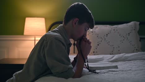 Boy-praying-beside-his-bed