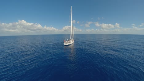 FPV-drone-flight-past-white-Oyster-luxury-sailing-yacht-in-azure-open-ocean