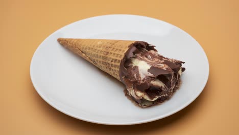 Melting-chocolate-ice-cream-cone-on-a-plate
