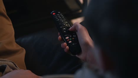 Person-clicking-buttons-on-a-remote