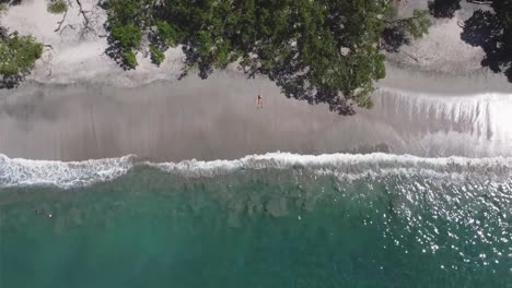 Drohnenansicht-Eines-Mädchens,-Das-An-Einem-Paradiesischen-Strand-In-Costa-Rica-Liegt