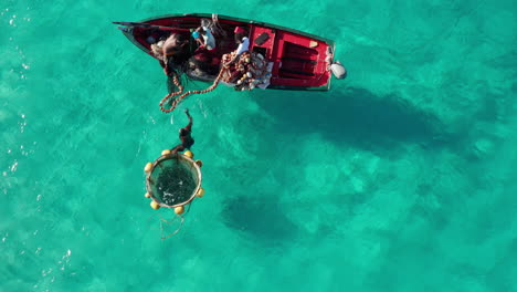 Top-down-view-of-African-fishermen-fishing-in-colorful-turquoise-water