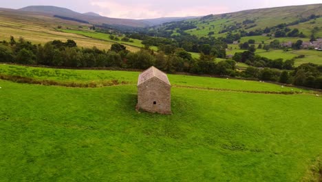 Slow-horizonal-tracking-aerial-shot-of-isolated-barn-in-Yorkshire-Dales-valley