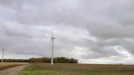 A-large-wind-turbine-in-a-rural-farm-field-from-the-window-of-a-travelling-vehicle,-Toronto,-Canada