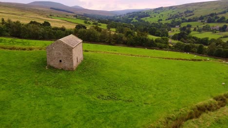 Slow-forward-tracking-aerial-shot-of-isolated-barn-in-Yorkshire-Dales-valley