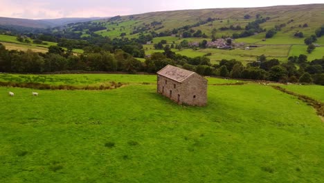 Slow-rotating-aerial-shot-of-isolated-barn-in-Yorkshire-Dales-valley