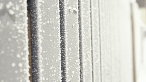 Hoarfrost-on-wooden-boards-in-closeup,-abstract-winter-background,-vertical