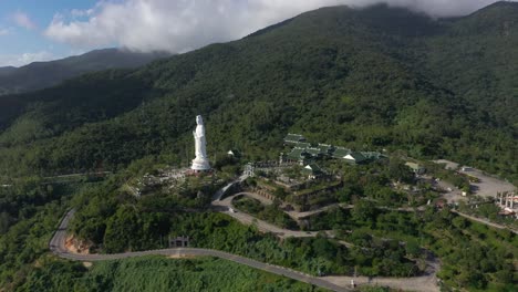 Luftaufnahme-Hoch-über-Der-Höchsten-Dame-Buddha-Statue-Und-Tempel-Mit-Riesigen-Bergen-Und-Ozean-In-Da-Nang,-Vietnam