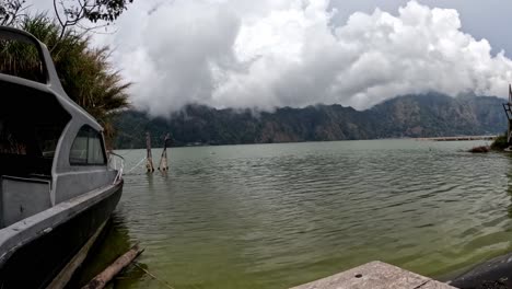 Time-Lapse-of-boat-on-lake-and-white-clouds-moving-fast-in-Kintamani,-Bali